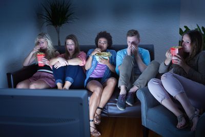 Lidé sledují film doma.  S prasklou kukuřicí.