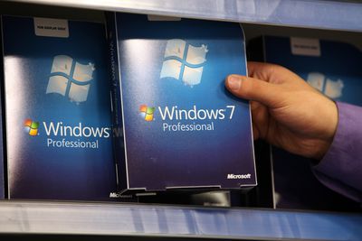 Ruka držící v krabici software Windows 7 v maloobchodním displeji