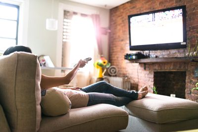 Žena, sledování televize na gauči