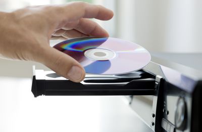 Muž, který vložil disk DVD-R do přehrávače DVD.