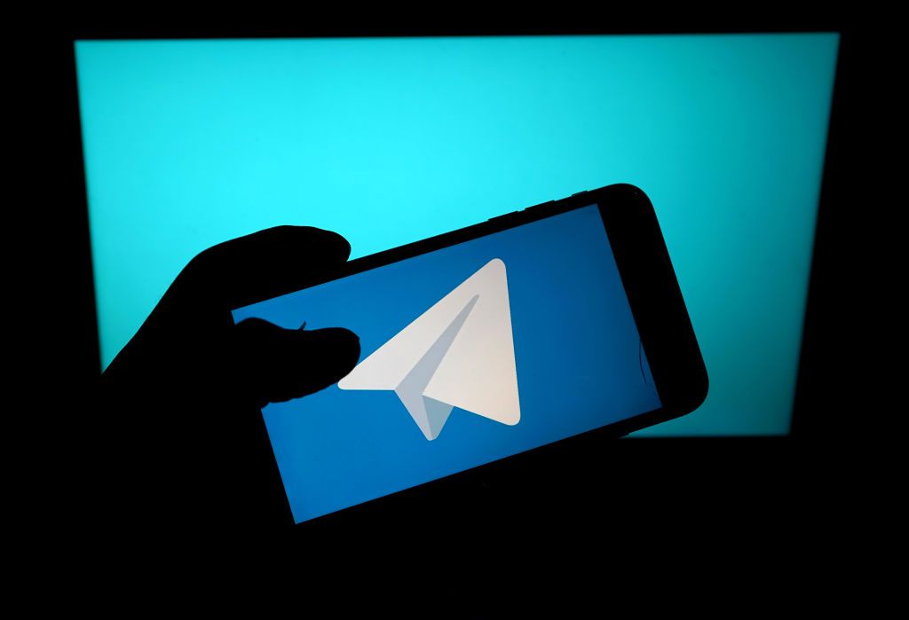 Logo Telegramu na smartphonu na modrém pozadí.