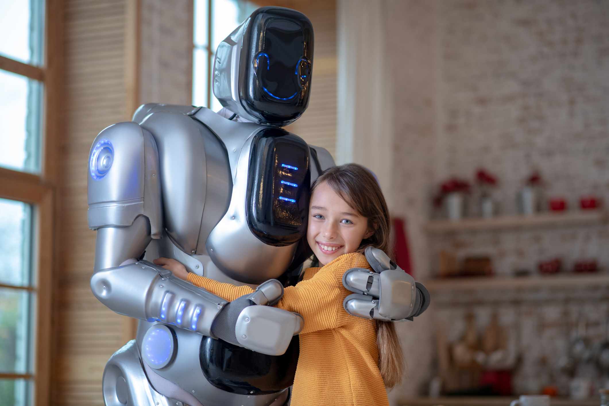 Dítě objímající robota, který na něm zobrazuje šťastnou tvář "obličeje" obrazovka.