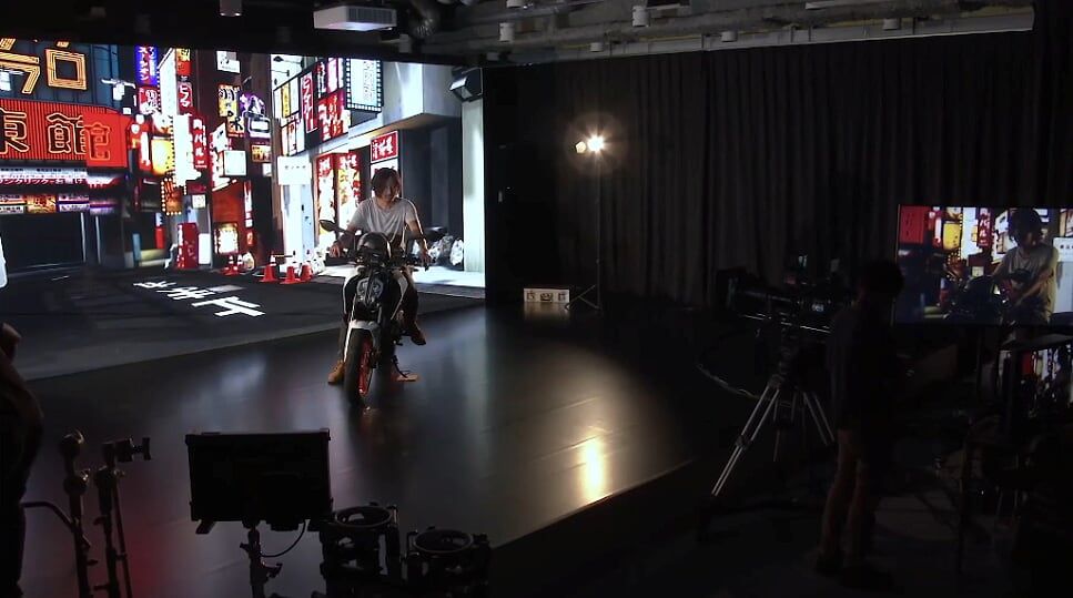 Herec na motocyklu před virtuální obrazovky