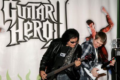 Hudebník Gene Simmons hraje na kytaru s mistrem Guitar Hero II JW McNayem v Virgin Megastore na Times Square, aby pomohl spustit Guitar Hero II na XBOX 360 11. dubna 2007 v New Yorku