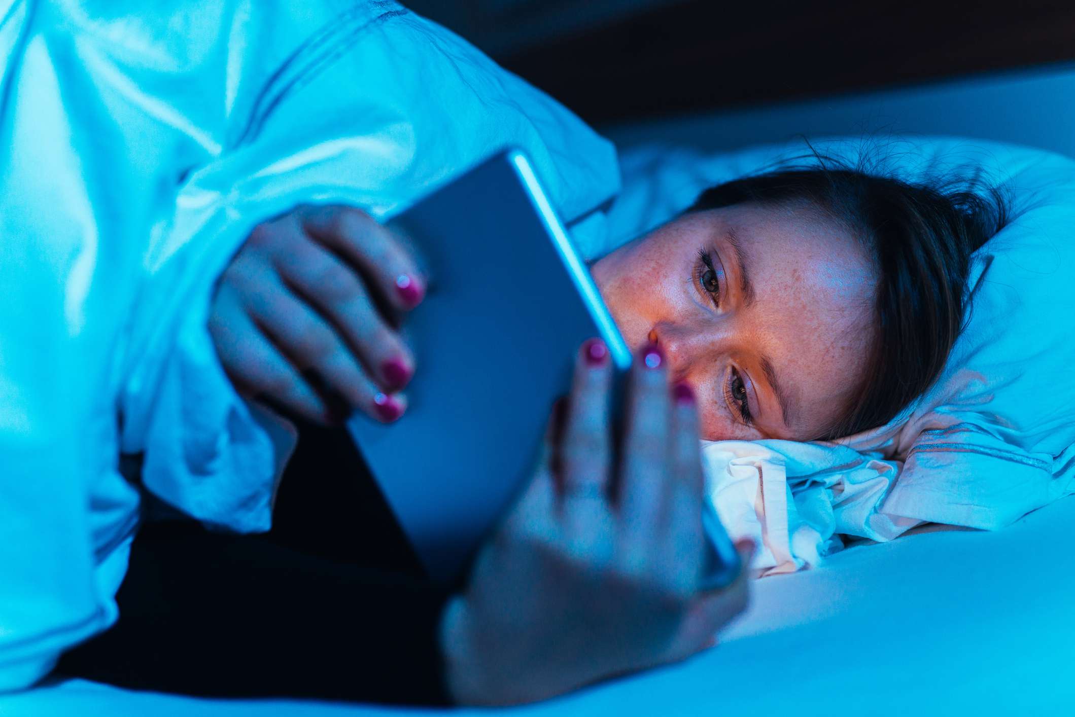 žena pomocí její tablet v posteli v noci