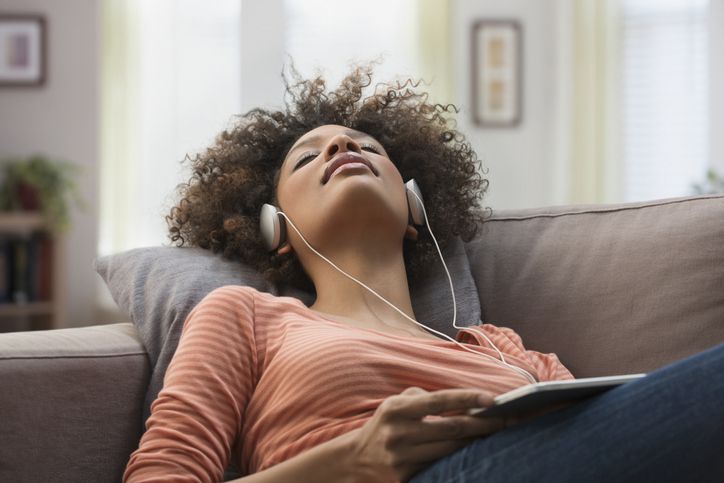 Žena nosit sluchátka a poslouchat hudbu na tabletu