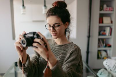 Mladý fotograf pomocí kamery v bytě