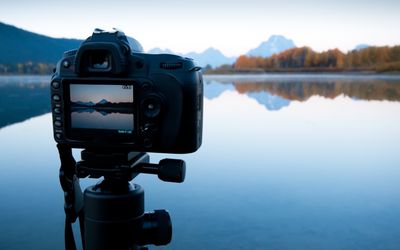 Fotoaparát na stativu zachycující jezera a hory