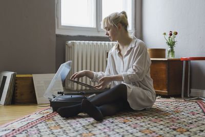 Žena pomocí gramofonu v obývacím pokoji