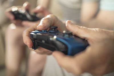 Detail ruky držící ovladač videoher