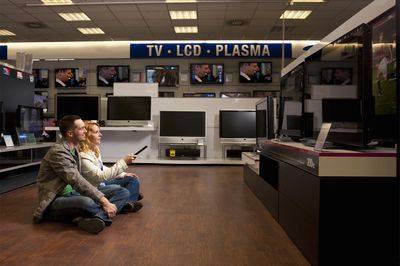 Mladý pár kontrolující televizi - LCD vs plazma