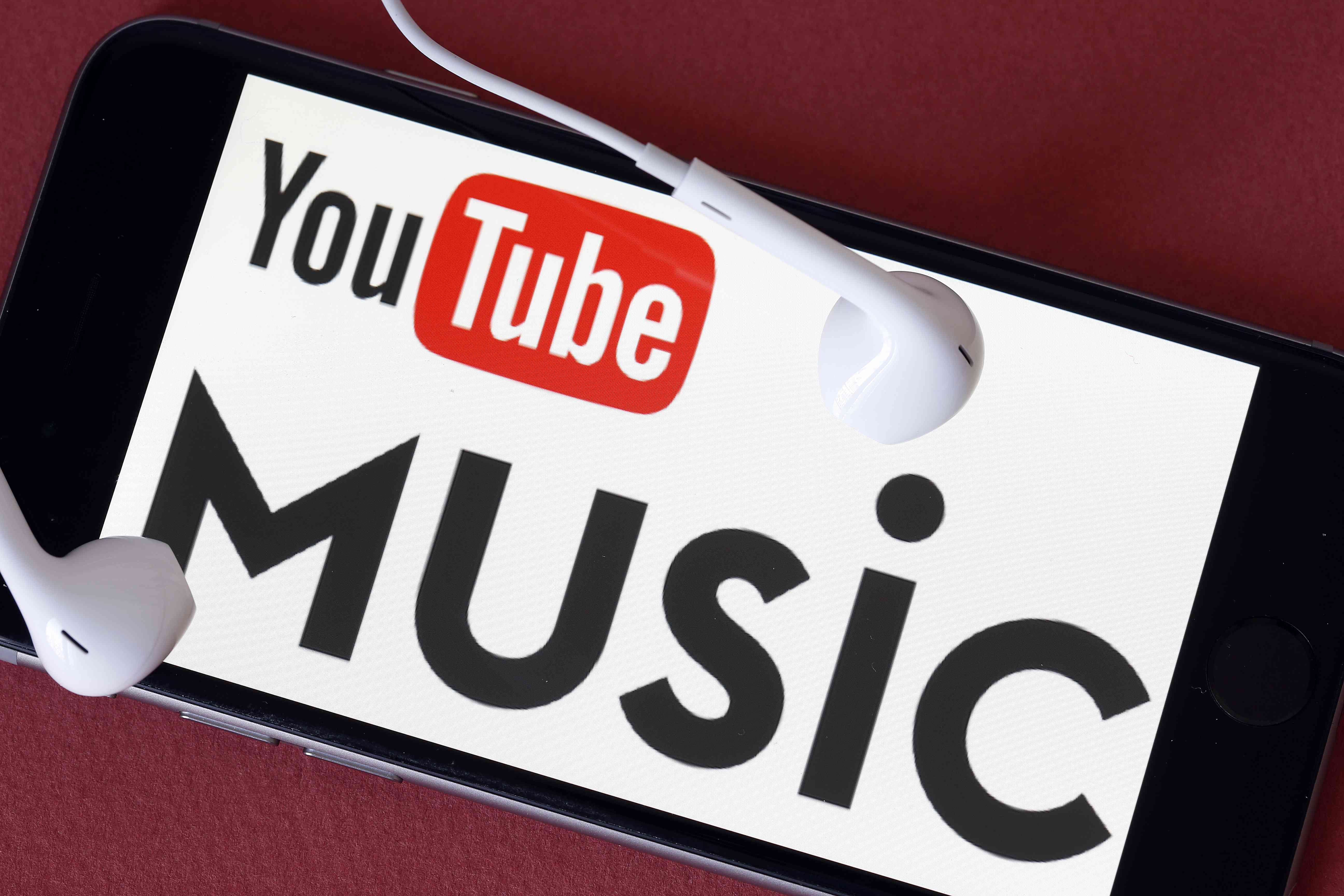 Logo YouTube Music na smartphonu se sluchátky