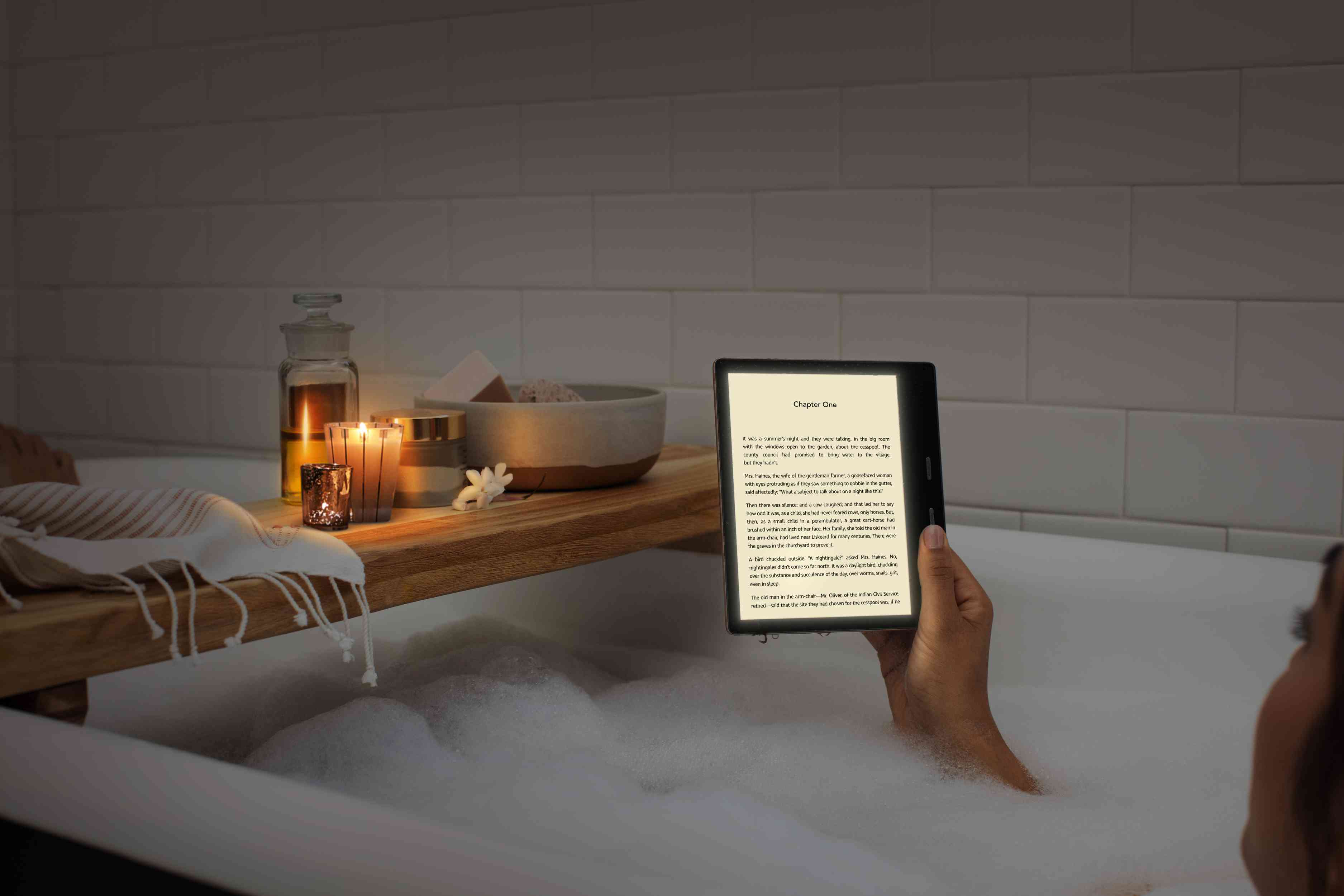 Někdo čte na tabletu Amazon Oasis a máče ve vaně.