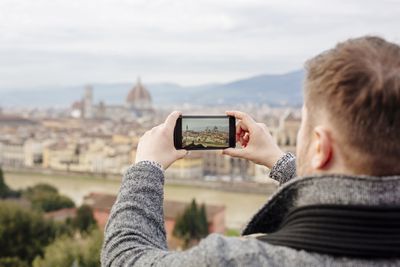 Turista fotografování panorama Florencie s jeho chytrý telefon