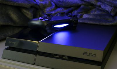 Konzole PlayStation 4 s ovladačem spočívajícím na ní