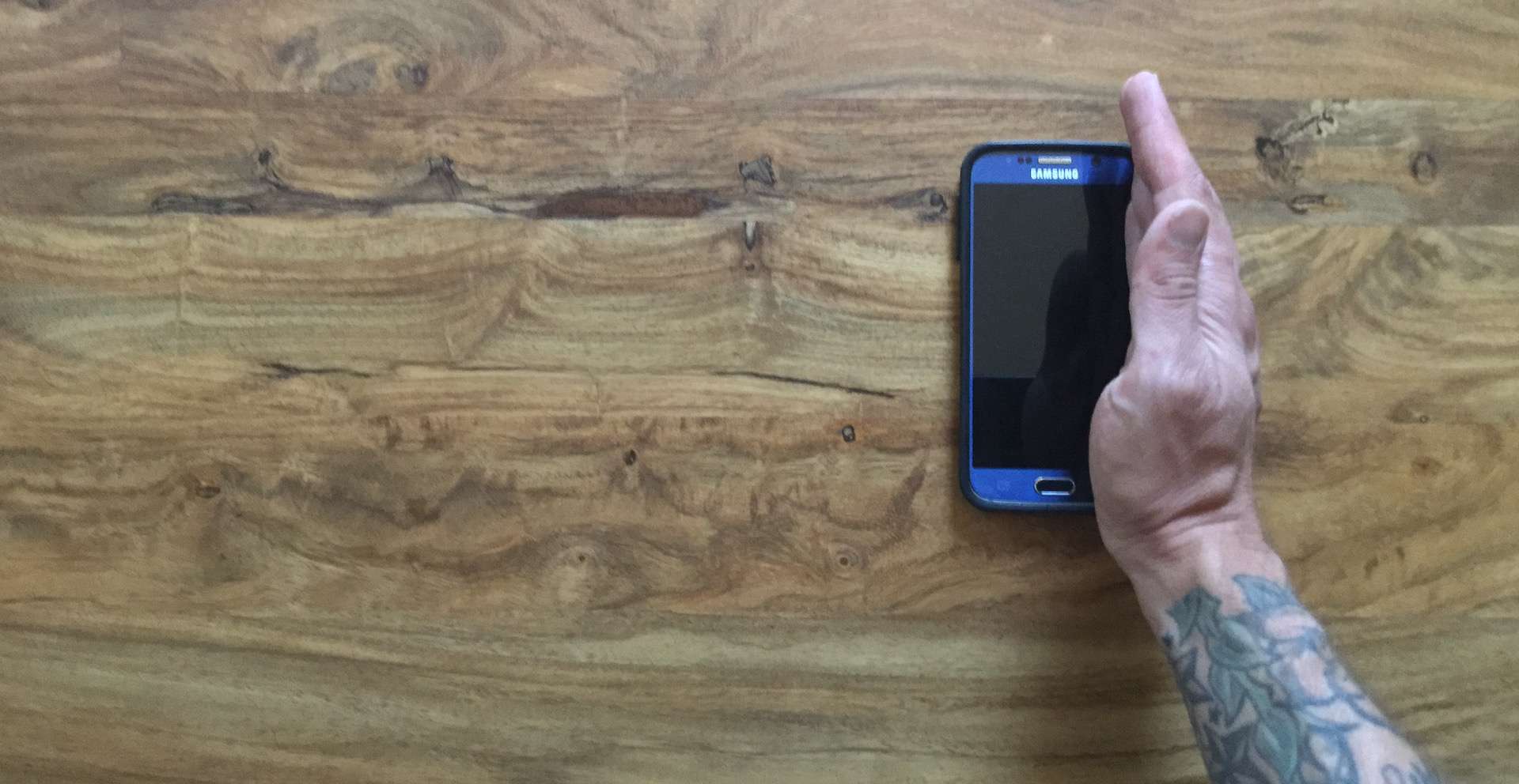 Mužská ruka je svisle na okraji Samsung S6.