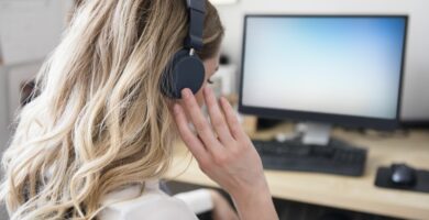 caucasian woman listening to headphones at computer desk 758282915 5c9019ee46e0fb00015558f5