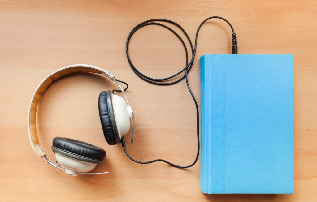 headphones and a book 160005705 57d1e8775f9b5829f44815c6