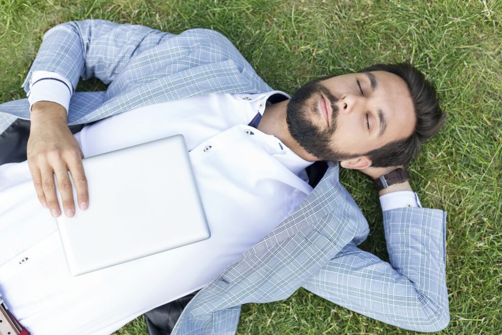 man lying on lawn with closed eyes holding digital tablet 590773539 5b47a26a46e0fb00549a0009
