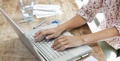 woman using laptop at dining room table 143070370 5ab90aa5fa6bcc003607ef80