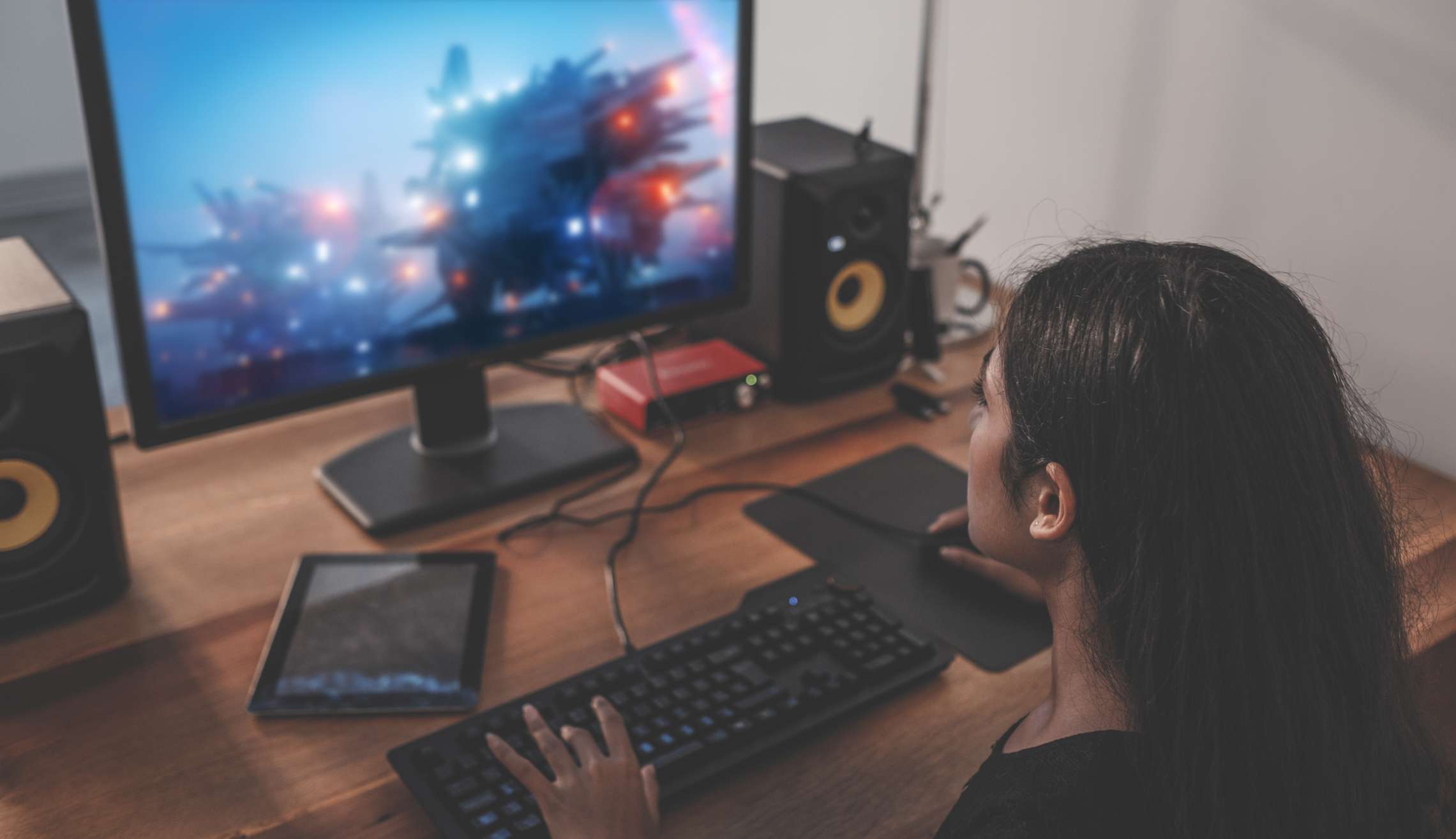 Mladá žena hraní videoher na počítači doma