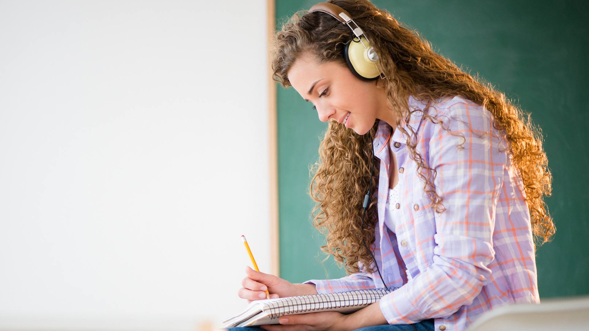 Studentka studující se sluchátky s potlačením hluku