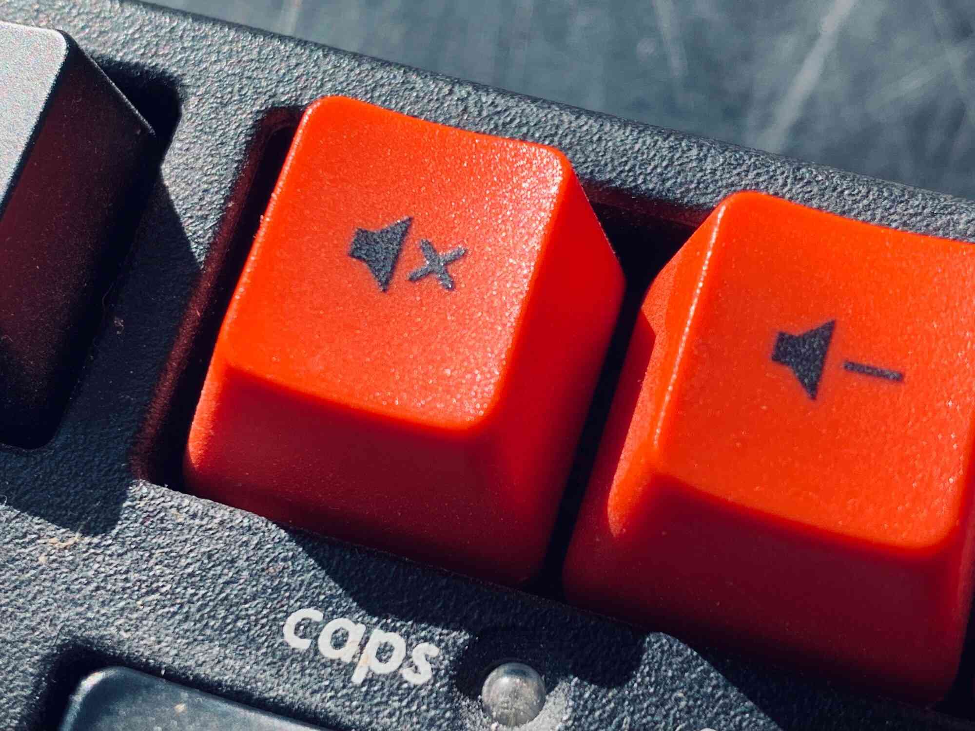 Zavřete obrázek červených kláves pro ztlumení a snížení hlasitosti mechanické klávesnice
