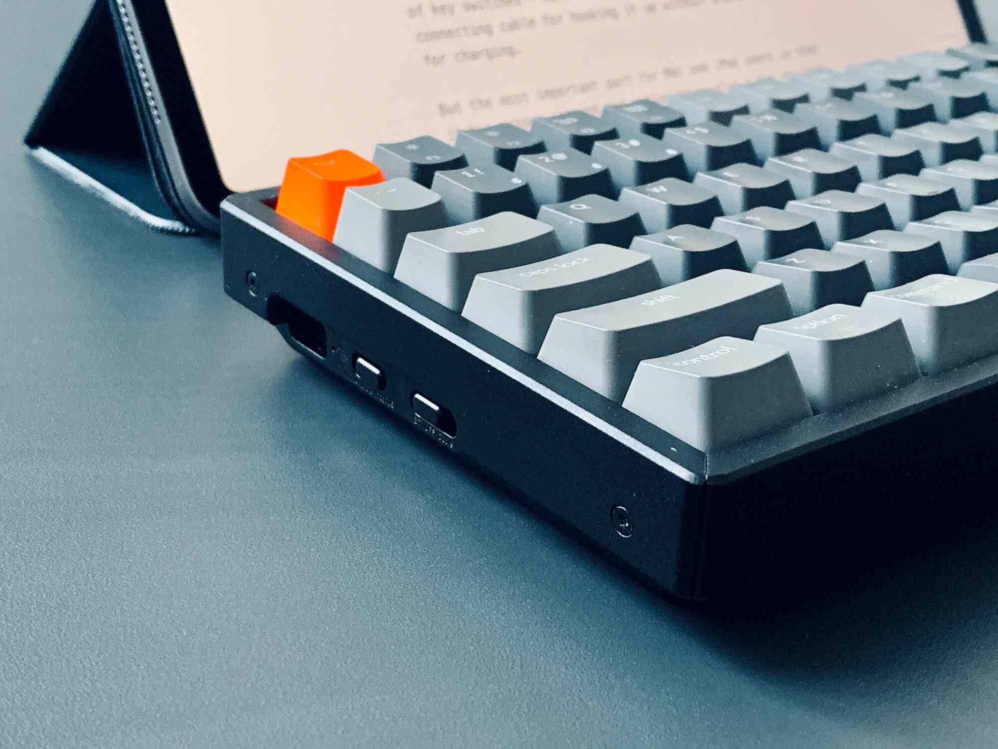 Vysoká mechanická klávesnice položená před tabletem