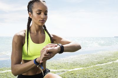 Mladá běžkyně při pohledu na fitness tracker