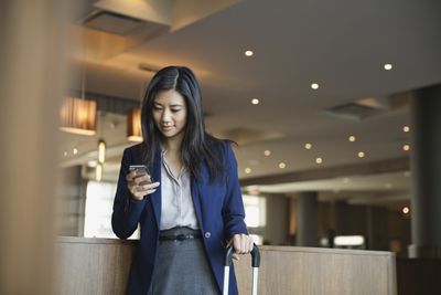 Podnikatelka pomocí chytrého telefonu v hotelové hale
