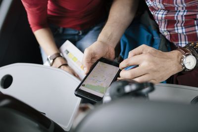 Lidé prohlížející si aplikaci mapy na smartphonu