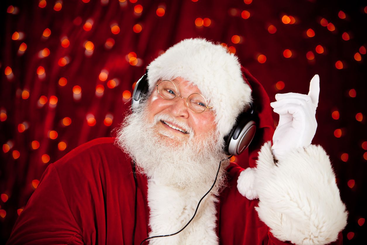 Santa poslouchá vánoční hudbu ve sluchátkách.