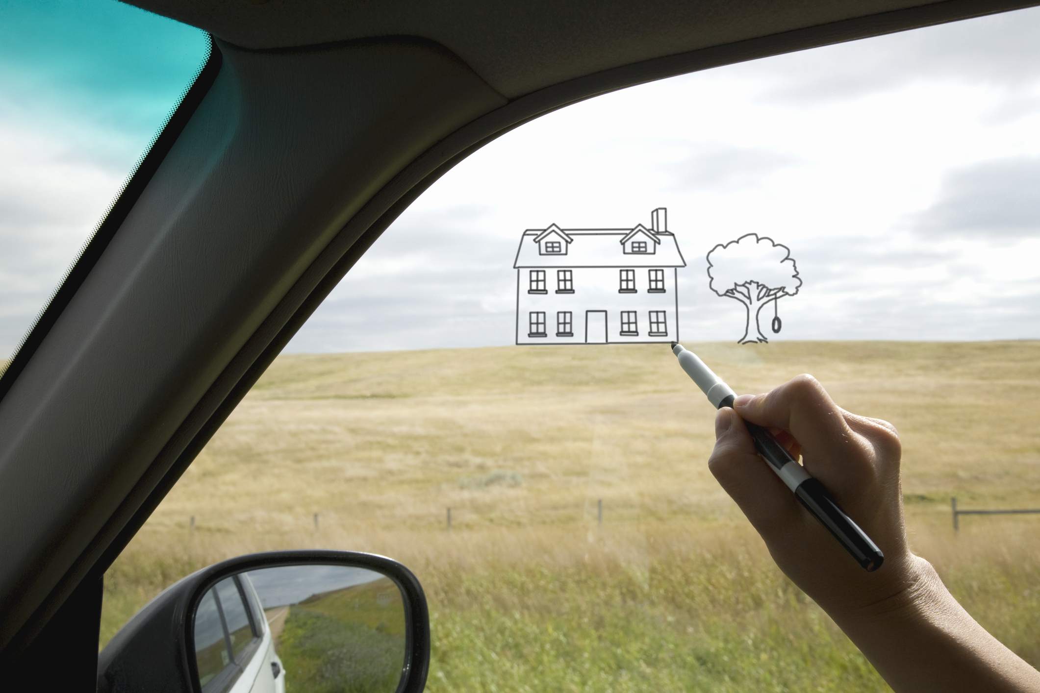 Osoba nakreslí dům na okně auta