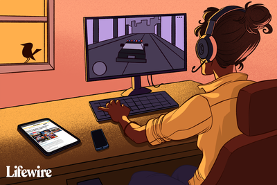 Osoba hrající GTA Vice City na PC a číst cheat na Lifewire přes tablet