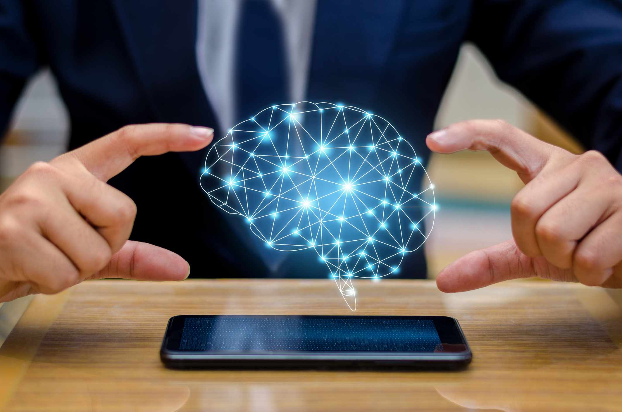 Digitální složený obraz podnikatele pomocí smartphonu s ikonou mozku plovoucí nad ním.