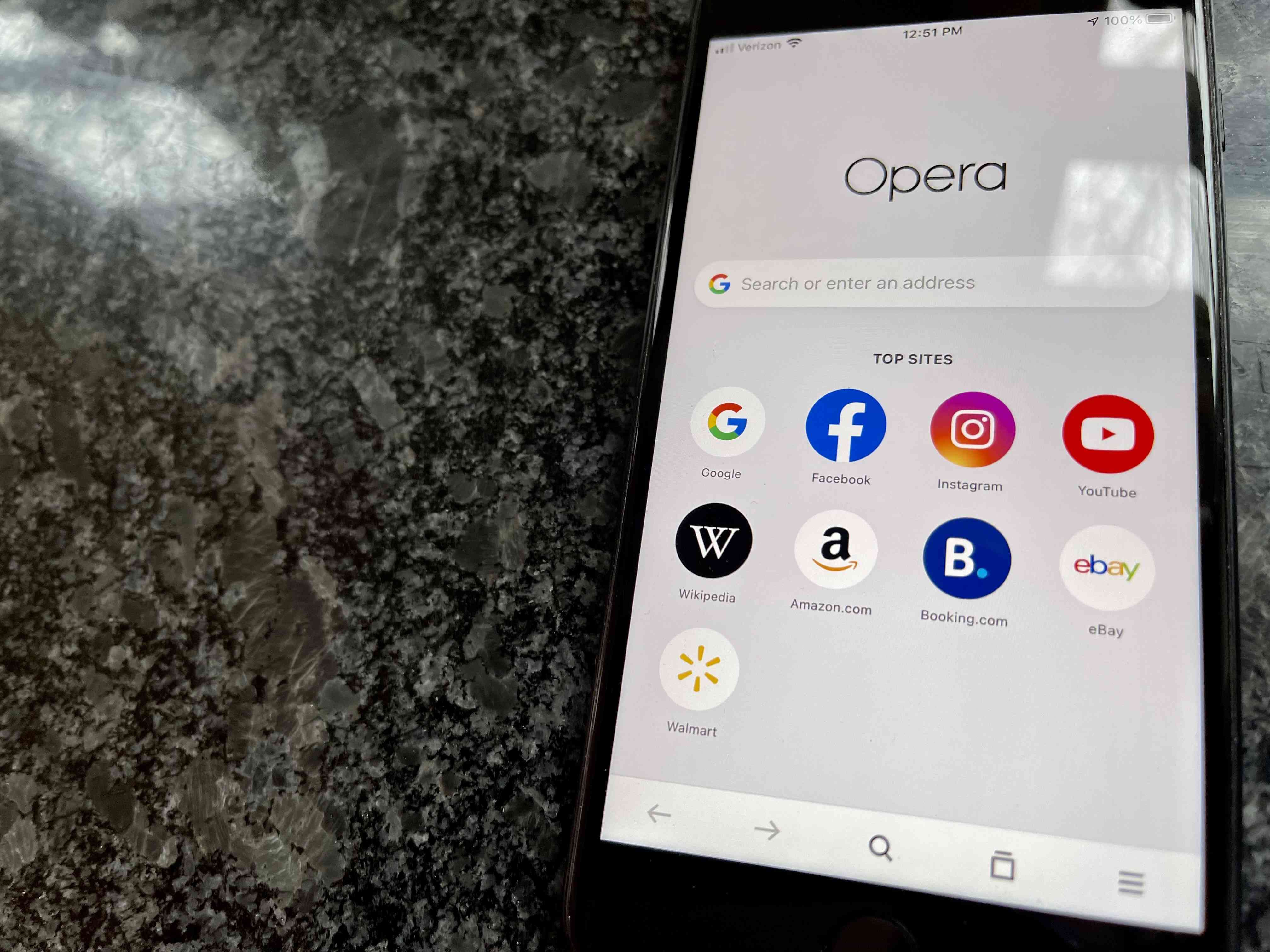 iPhone běží s prohlížečem Opera a odpočívá na desce