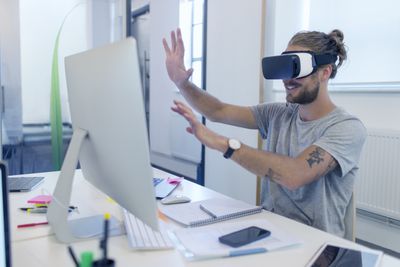 Počítačový programátor programování brýlí simulátoru virtuální reality na počítači v kanceláři