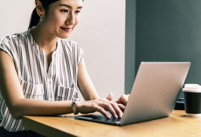 Žena pracující na přenosném počítači