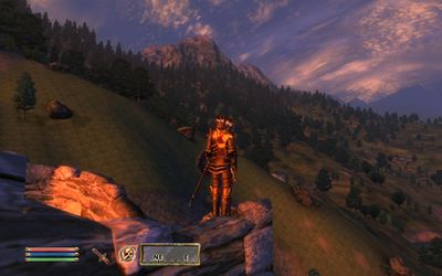 V Elder Scrolls IV: Oblivion stojí na útesu muž s výhledem na některé kopce.