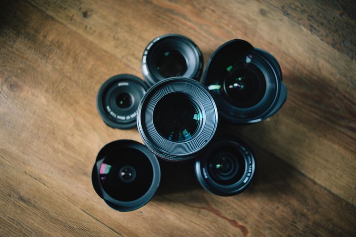 Objektivy fotoaparátu uspořádány na dřevěný stůl
