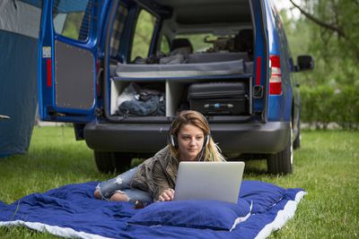 žena pomocí energie z auta k nabíjení notebooku na výlet