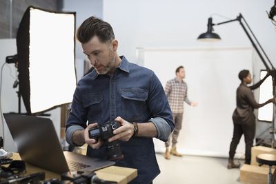 Fotograf ve studiu pomocí přenosného počítače