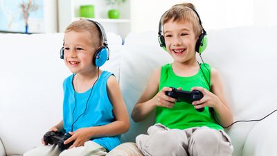 Dva chlapci hrají zábavné online videohry na PlayStation 4.