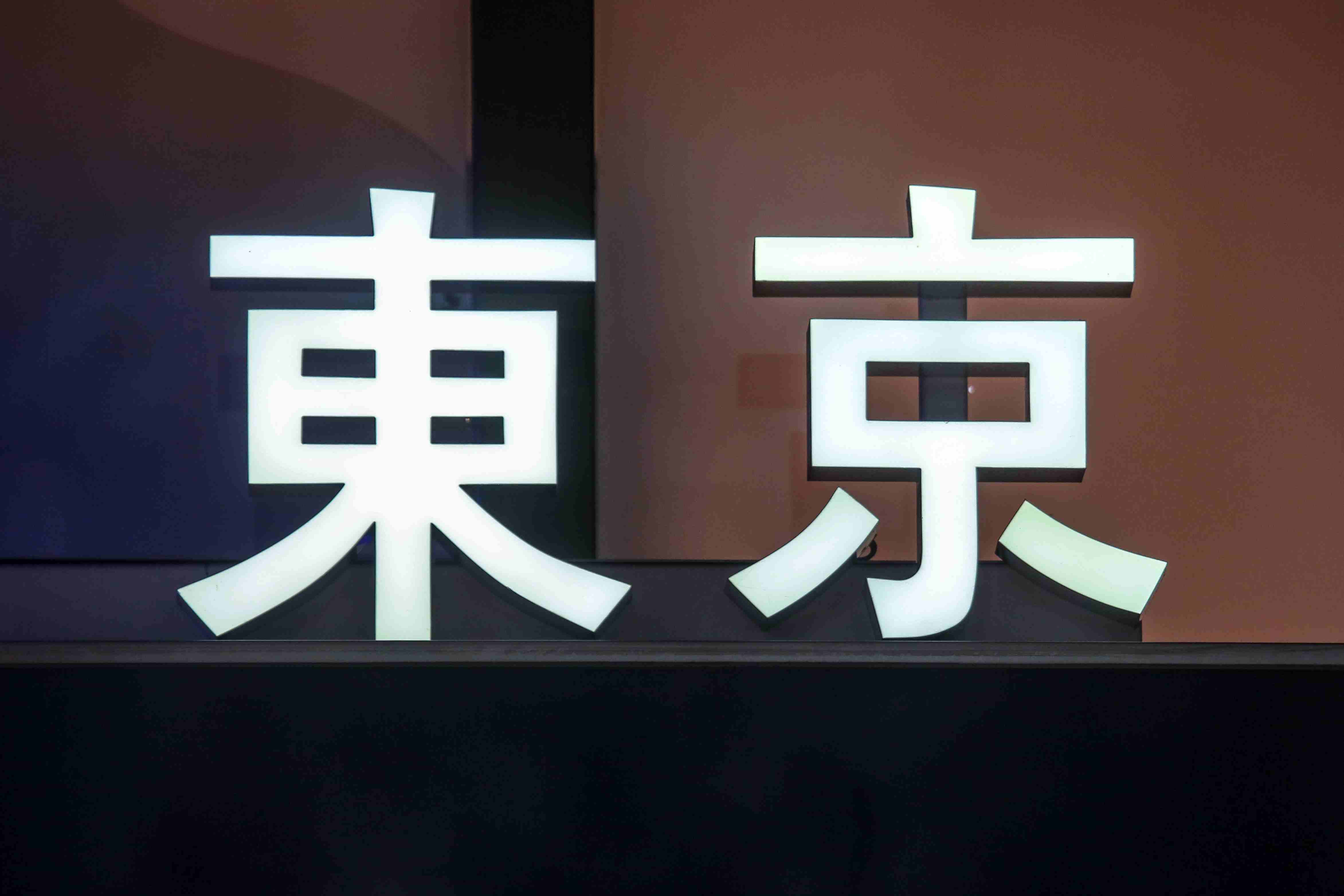 Vnitřně osvětlený znak názvu města Tokio v kanji nebo tradiční čínské znaky