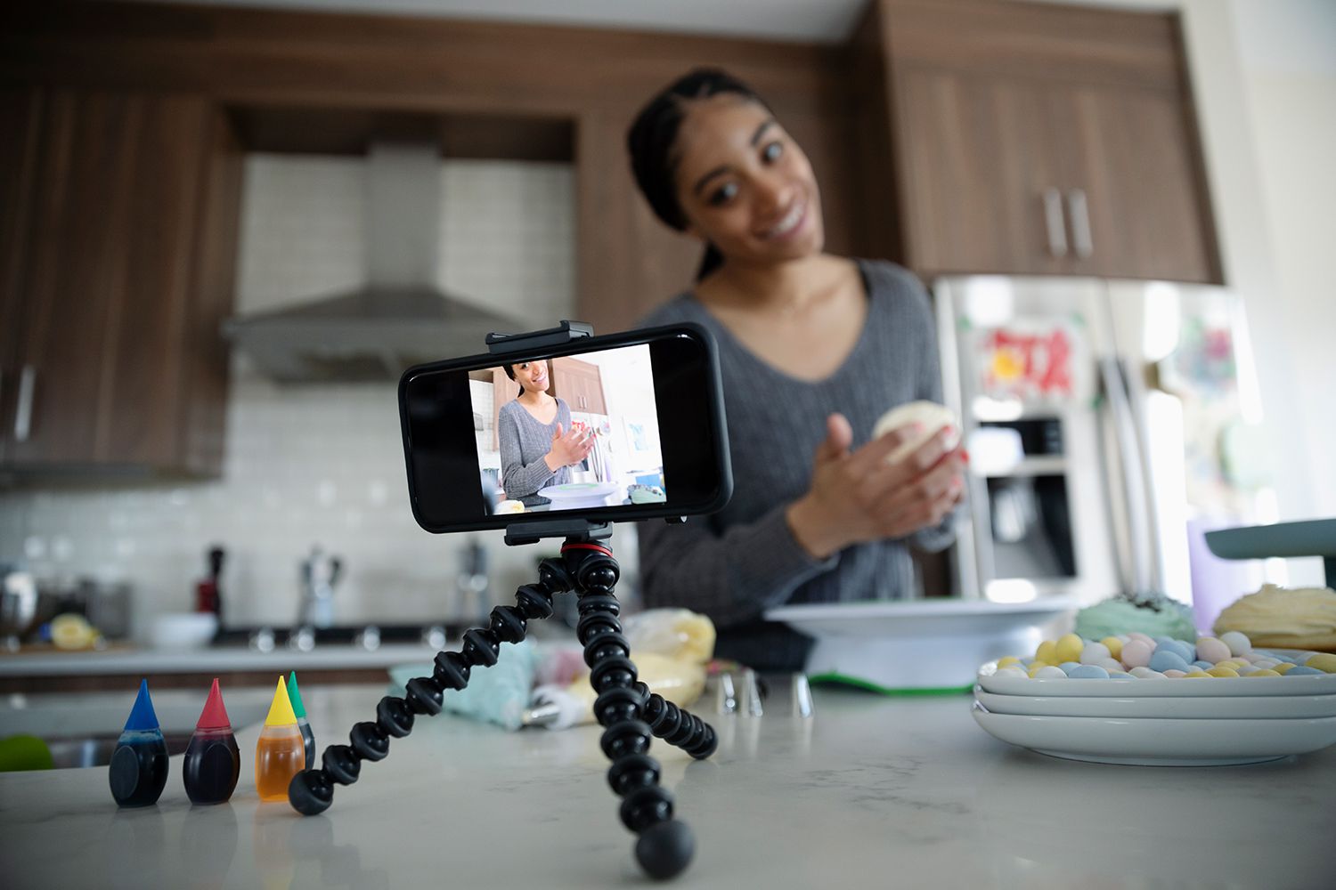 Dospívající dívka vlogging, zdobení cupcakes v kuchyni