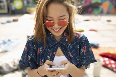 Žena s sluneční brýle pomocí smartphonu