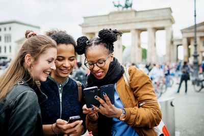 Skupina přátel při pohledu na mobilní telefon