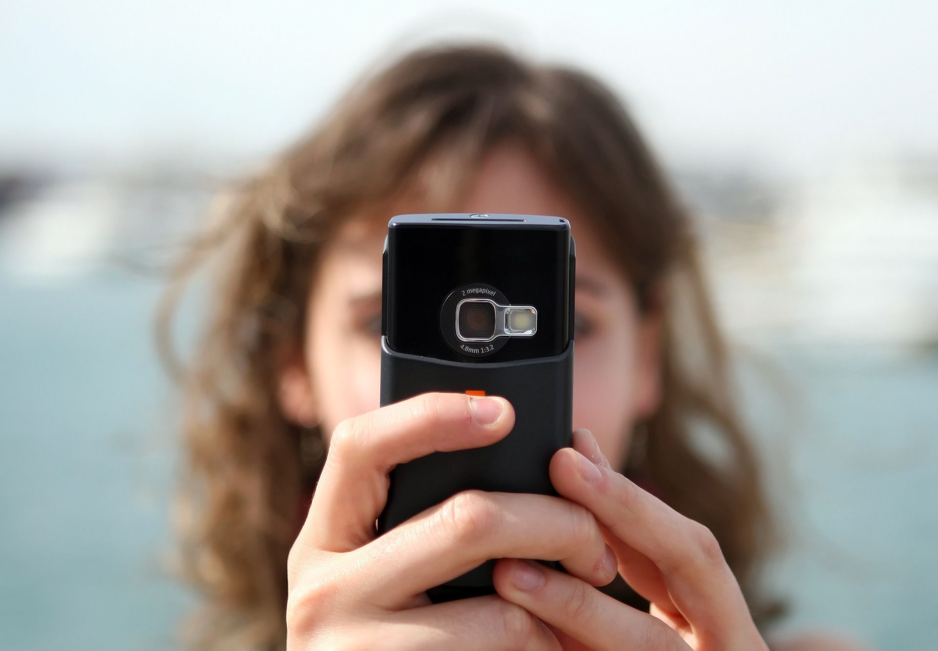 Žena držící fotoaparát fotoaparátu před její tvář.