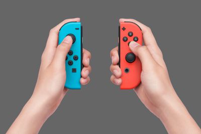 Ruce držící Nintendo Joy-Cons