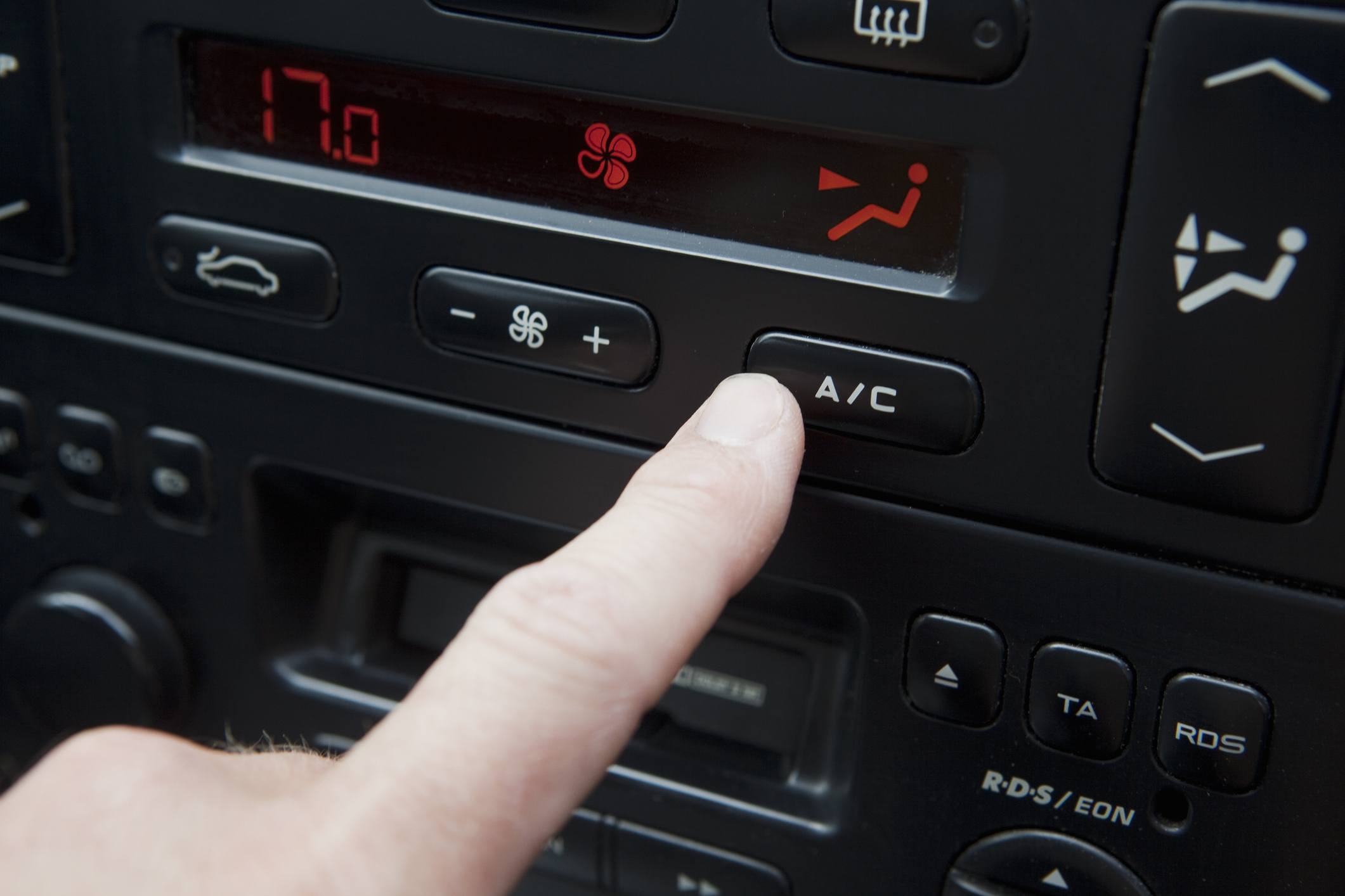 Ruční mačkání tlačítka AC v autě